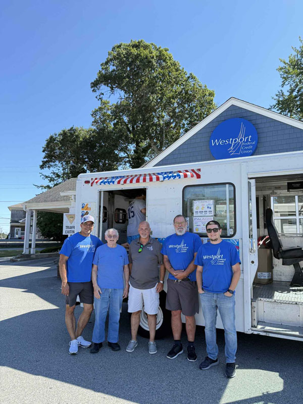 Group of people posing in front of a food truck.