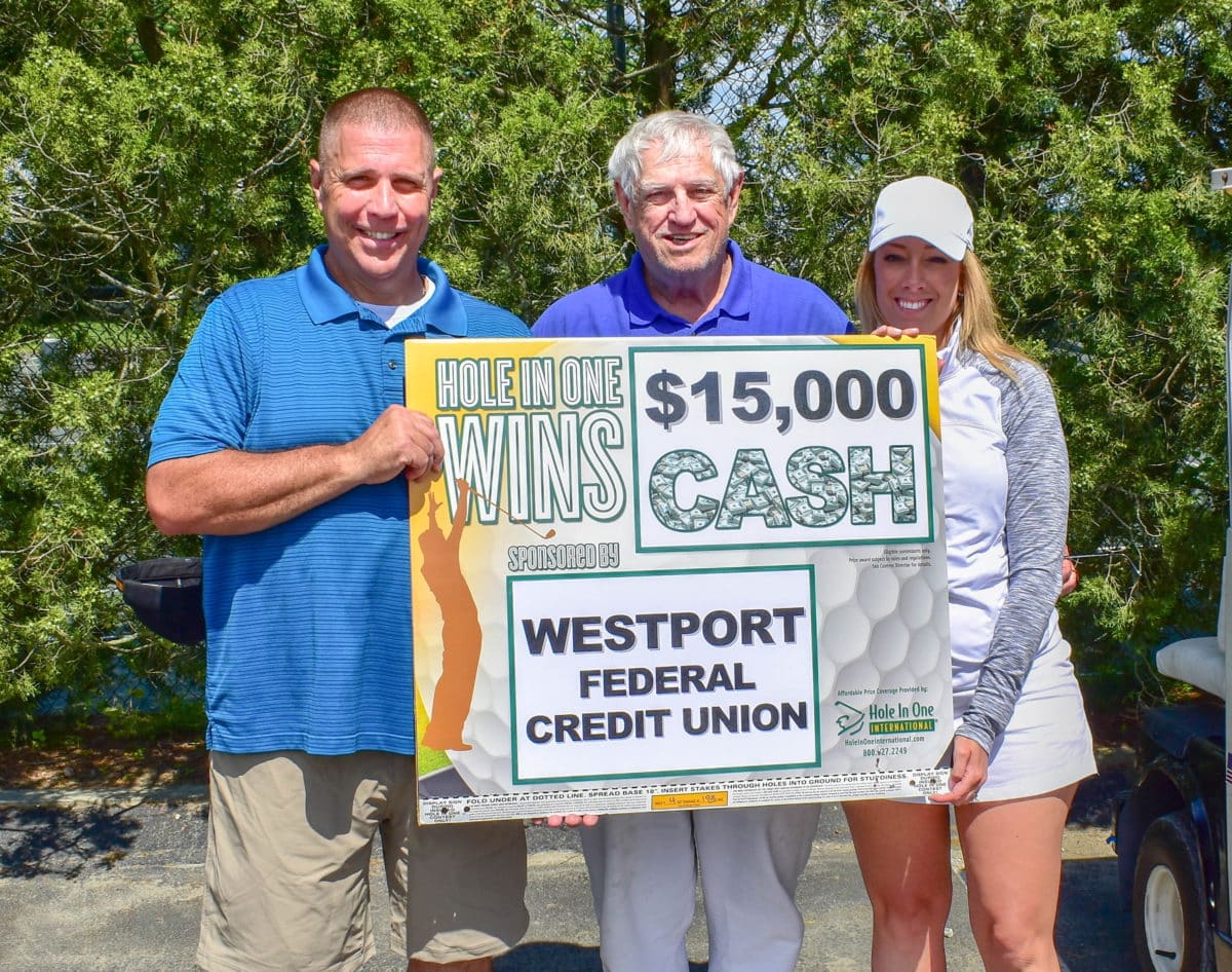 Three people holding a $15,000 cash Hole in One prize sign.