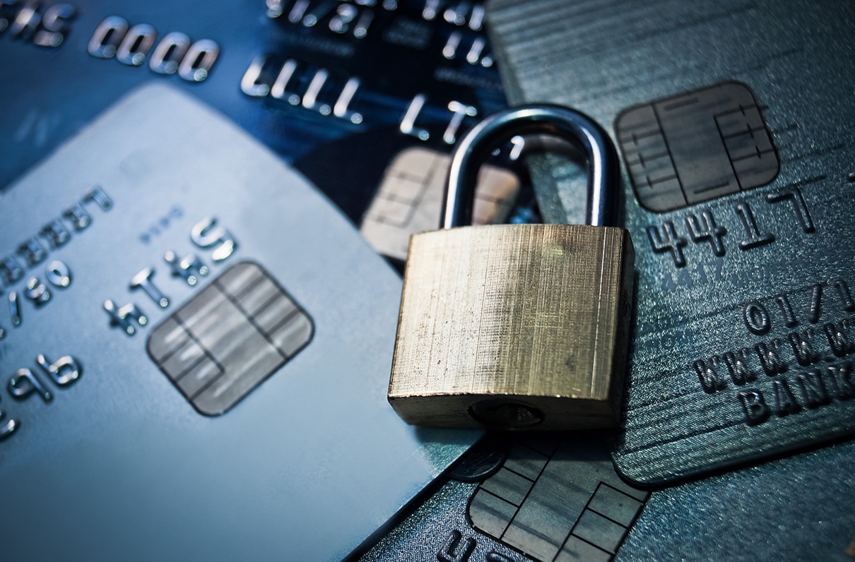 Close-up of a padlock resting on several credit cards, symbolizing financial security.