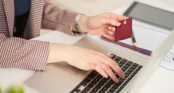 Person using laptop with credit card